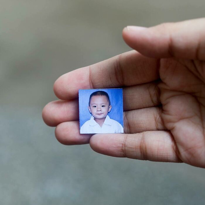 Hand holding a small photo of a young boy, representing moving stories from Humans of New York.