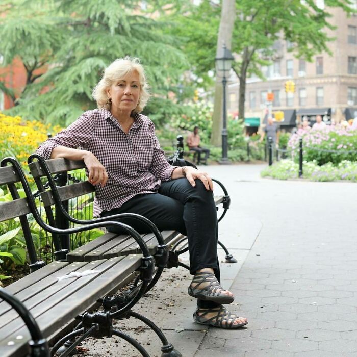 Woman sitting on a bench in a park, sharing one of the most moving stories from Humans of New York series.