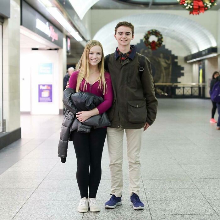 Two young people smiling and posing together in a busy urban setting for Humans of New York stories.
