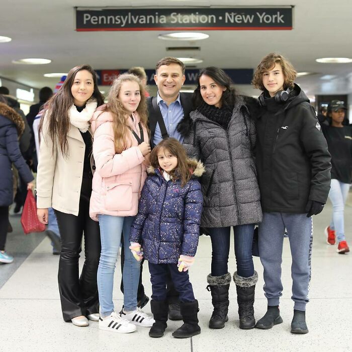 Family of six standing together at Pennsylvania Station New York, sharing a warm moment from Humans of New York stories.