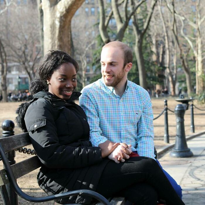 Couple sitting on a park bench sharing a moment, representing moving stories from Humans of New York in an outdoor setting.