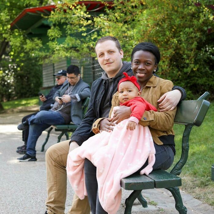 A diverse family sitting on a park bench sharing a warm moment, highlighting moving stories from Humans of New York.