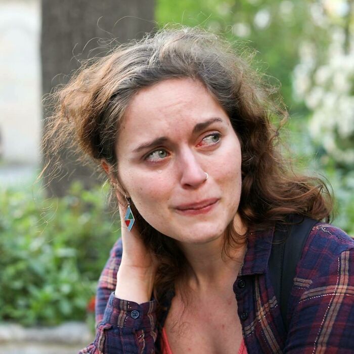 Woman with curly hair looking emotional outdoors, capturing one of the most moving stories from Humans of New York.