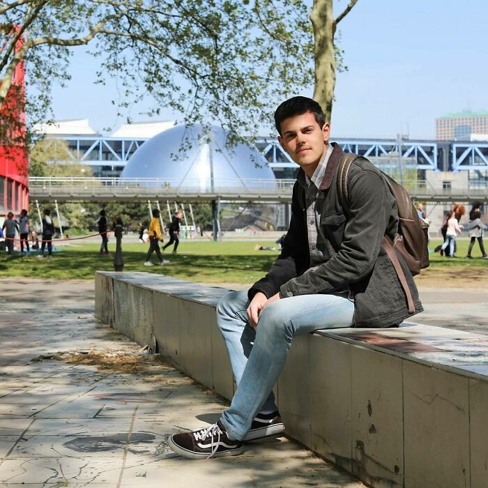 Young man with backpack sitting outdoors in New York park, part of moving stories from Humans of New York collection.
