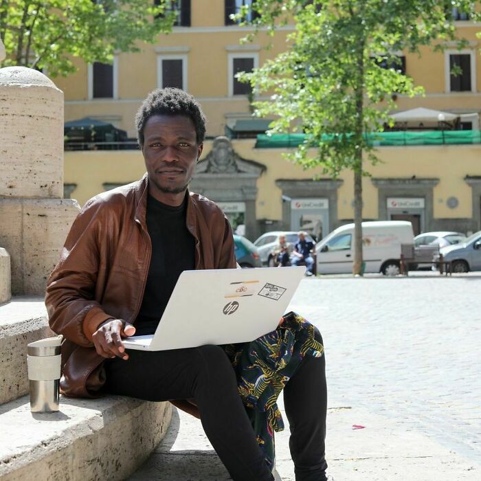 Man sitting outdoors with a laptop, sharing one of the most moving stories from Humans of New York in a city setting.