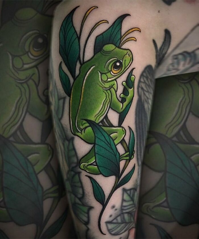 Creative frog tattoo design of a vibrant green frog with leaves, showcasing intricate artistry and detail.