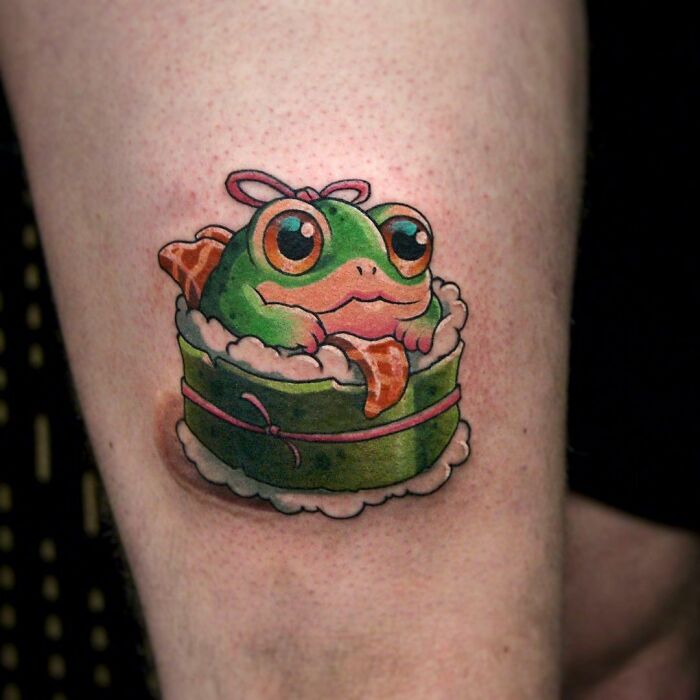 Cute and colorful frog tattoo nestled in a sushi roll, showcasing creative design elements.
