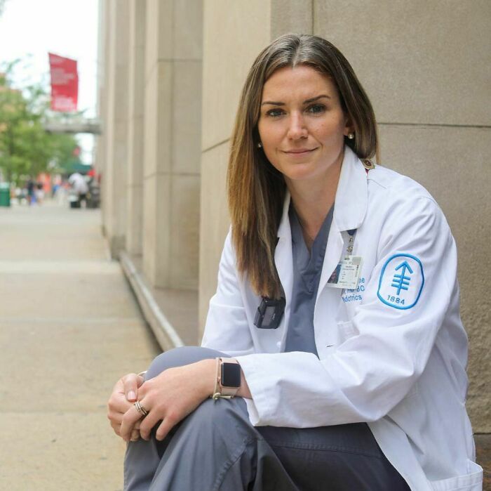 Young woman in medical coat sitting outside, representing moving stories from Humans of New York.