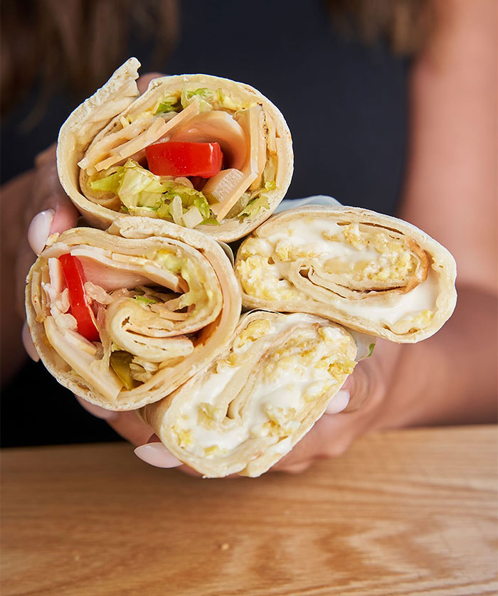 A Lunch idea featuring handheld lavash wraps filled with a variety of ingredients including lettuce, tomato, cheese, and scrambled eggs. A Lunch idea featuring handheld lavash wraps filled with a variety of ingredients including lettuce, tomato, cheese, and scrambled eggs.