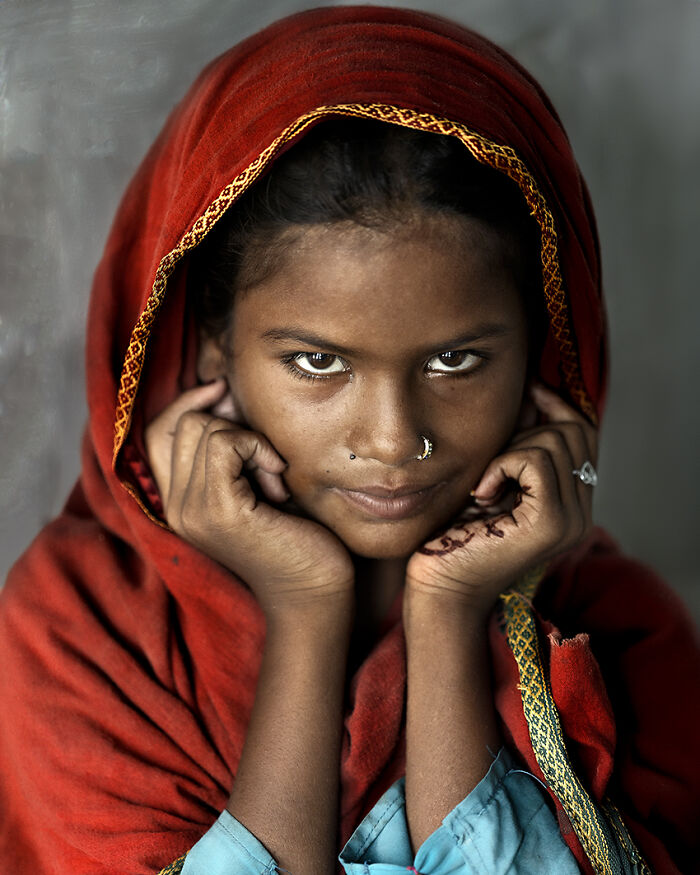 Portrait of a girl in a red shawl showcasing breathtaking images in the 2024 travel photography awards.
