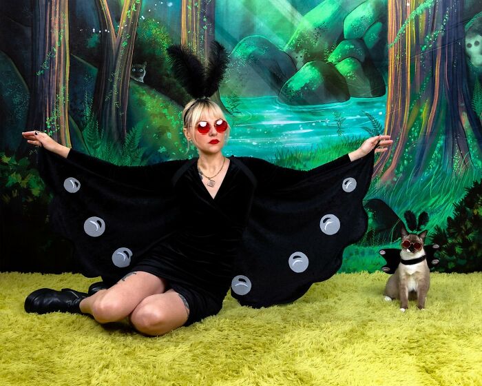 Woman and her cat dressed in matching quirky costumes posing for silly portraits with pets and their owners indoors.