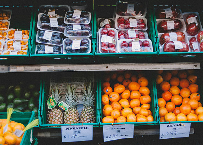 Fresh fruits like pineapples, satsumas, and oranges displayed at a market, highlighting common adult problems.