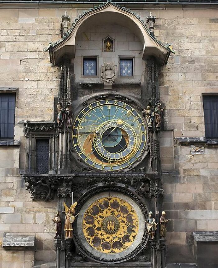 Ancient marvels: intricate astronomical clock on historic stone building facade.