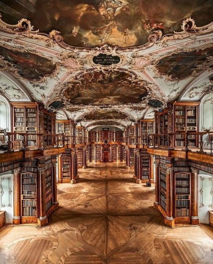Ornate library interior with intricate ceiling art, showcasing ancient marvels in architectural design.