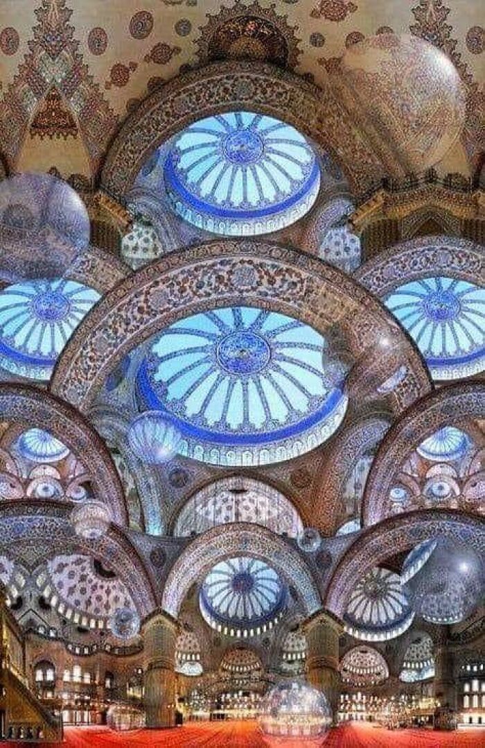 Intricate domed ceiling showcasing ancient marvels with detailed architectural patterns and vibrant blue hues.