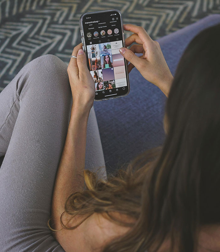 Woman scrolling social media on a smartphone, illustrating the theme of encountering the world’s worst parents stories.