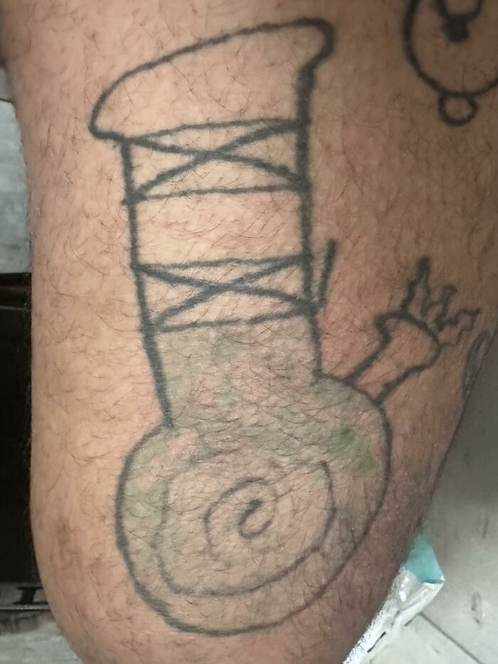 Unusual tattoo design resembling a sketched object with spiral and bands on skin, shared in a Facebook group.