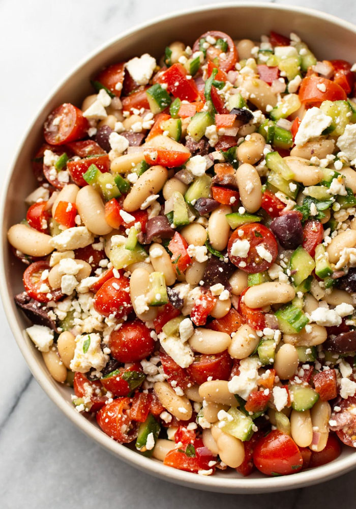 A Lunch idea featuring a vibrant Mediterranean bean salad with white beans, cherry tomatoes, cucumbers, olives, feta cheese, and chopped bell peppers. A Lunch idea featuring a vibrant Mediterranean bean salad with white beans, cherry tomatoes, cucumbers, olives, feta cheese, and chopped bell peppers.