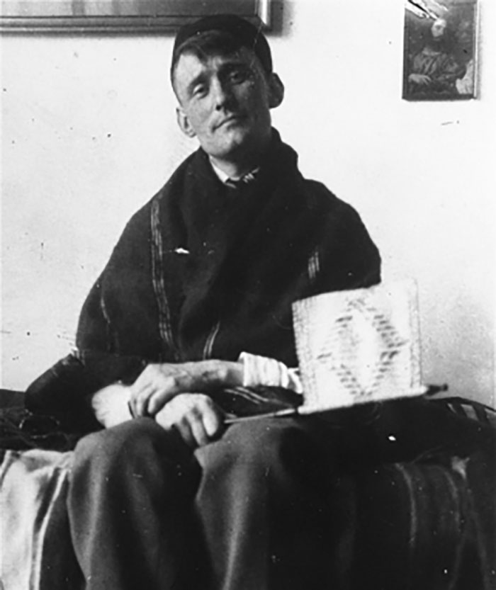 Black and white photo of a man sitting on a bed, representing iconic last words shared in history.