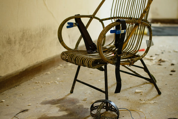 Abandoned vintage electric chair in a worn room, evoking the historical significance of iconic last words.
