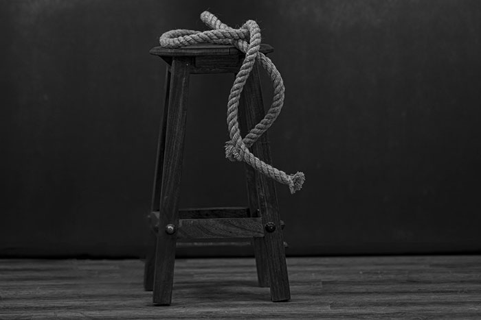 Wooden stool with a coiled rope hanging on it, symbolizing iconic last words in history and final moments.