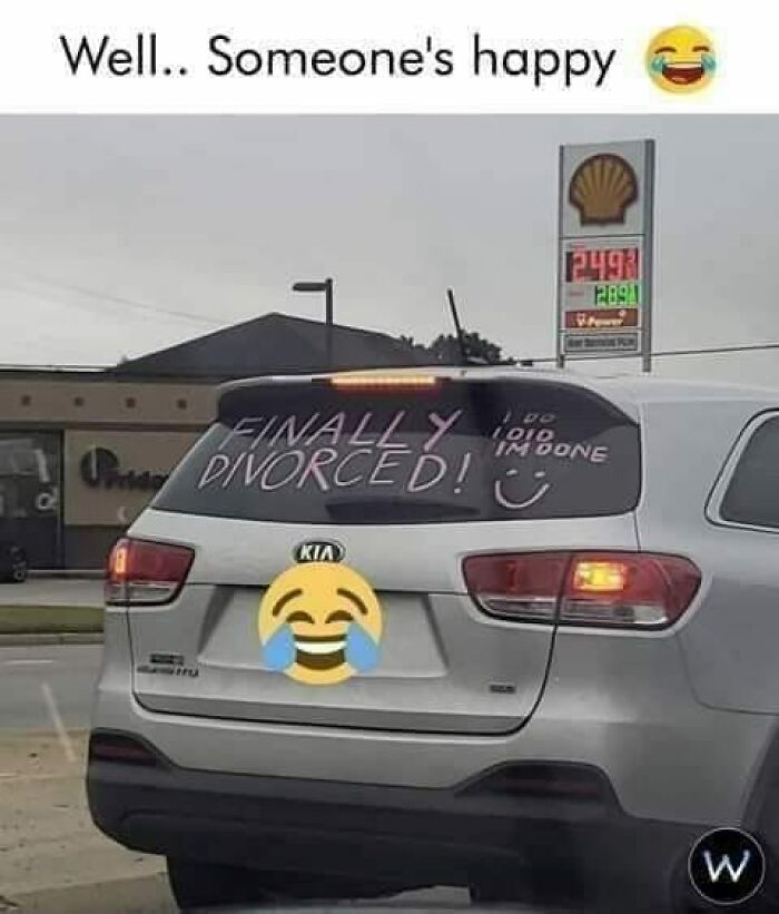 Car with "Finally Divorced!" message on the rear window, creating a funny moment for drivers.