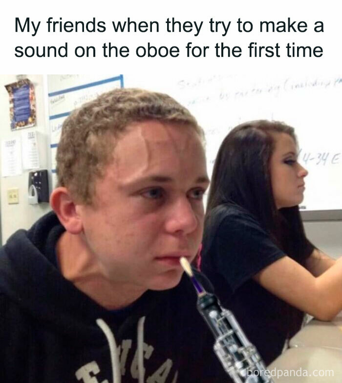 Young man struggling to play the oboe for the first time, humorously straining, capturing the essence of music memes.