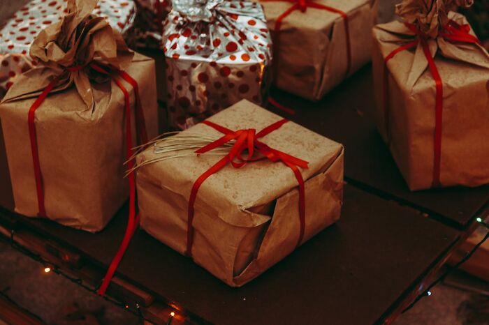 Several brown paper wrapped gifts with red ribbons, illustrating moments when white lies totally backfired on people.
