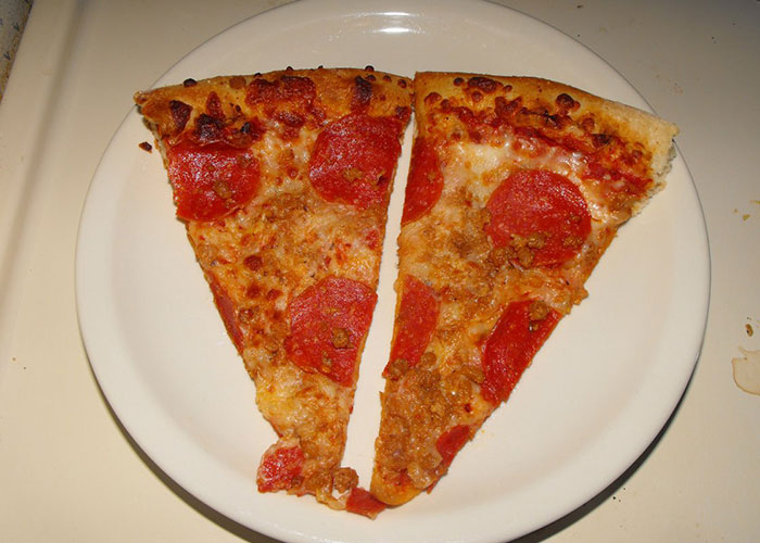 Two slices of pepperoni pizza on a white plate, illustrating a common example of food thieves at work.