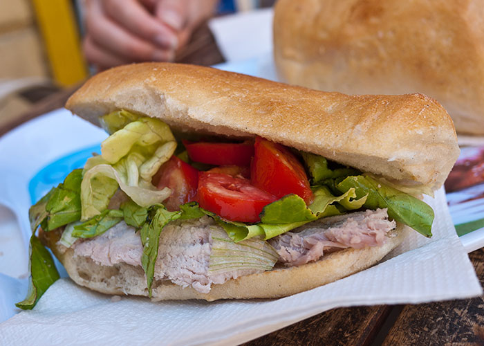 Sub sandwich with lettuce, tomato, and turkey on a white napkin, illustrating food thieves at work lesson.