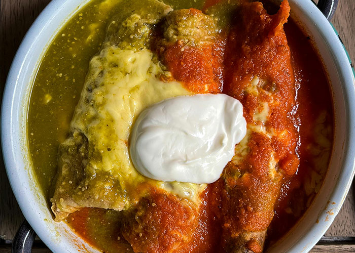 Close-up of a colorful plate of food with red and green sauce topped with sour cream, illustrating food thieves at work lessons.