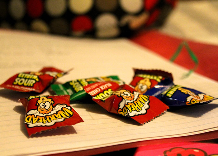 Juicy Head candy wrappers scattered on a notebook, illustrating food thieves at work lesson examples.