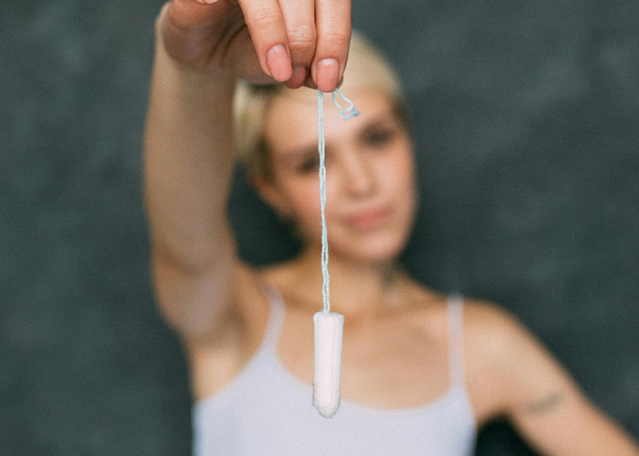 Person holding a tampon in front, symbolizing lessons taught to food thieves at work.
