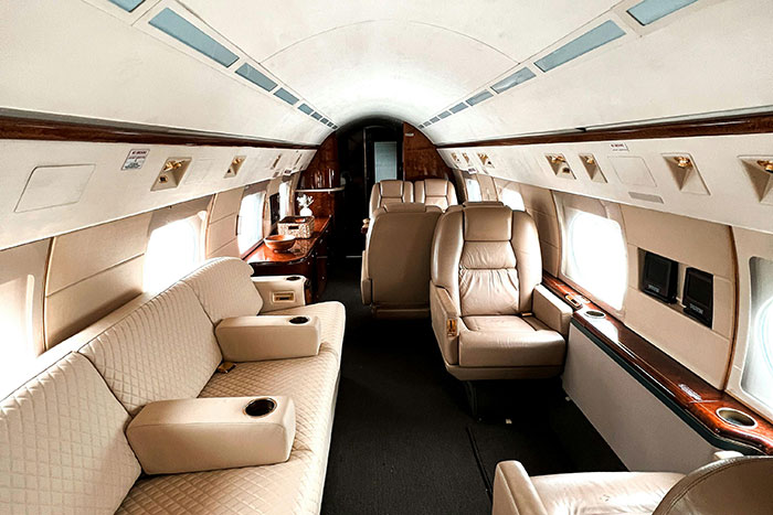 Luxurious private jet interior with leather seats and stylish wood accents showcasing what ultra rich individuals can afford.