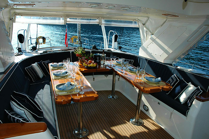 Luxury yacht dining area with elegant table settings, plush seating, and stunning water views for ultra rich experiences