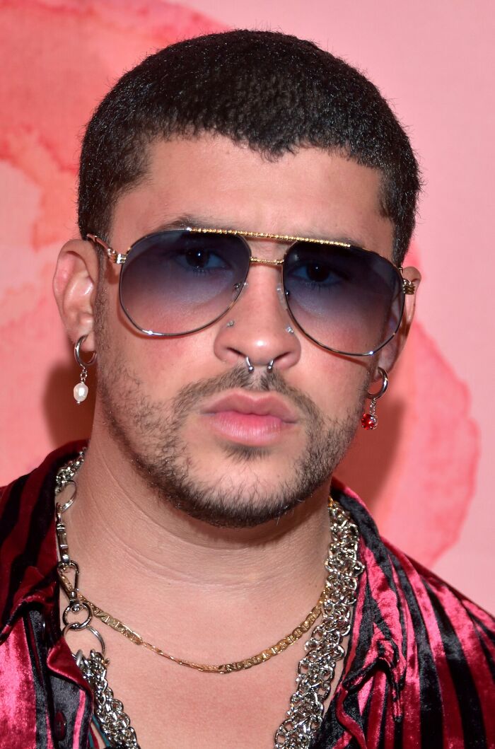 A person wearing sunglasses and a red outfit with a chain necklace, featured in a discussion on actors.