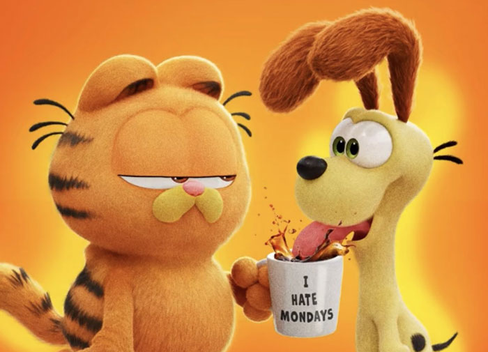 Cartoon duo with orange cat and yellow dog, cat holding a mug that says "I Hate Mondays".