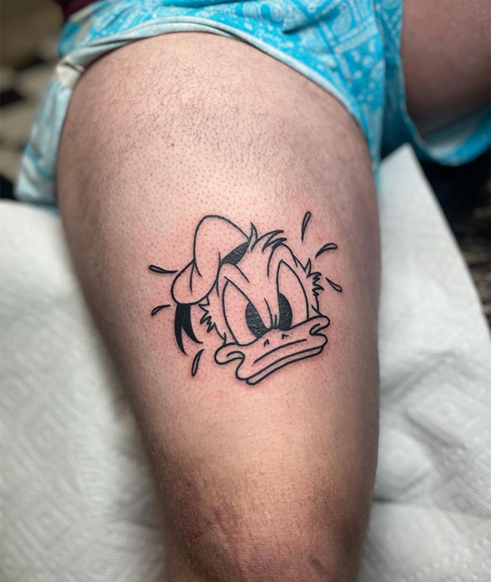  Nostalgic tattoo ideas for men featuring a bold linework design of an angry cartoon duck in a sailor hat, capturing expressive emotions and classic cartoon style for a playful look.