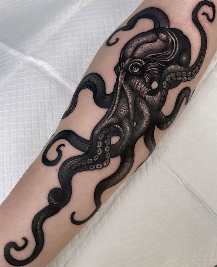  Bold tattoo ideas for men featuring a detailed black ink octopus design on the forearm, with intricate shading and realistic tentacle details to create a dynamic and captivating sea creature theme.