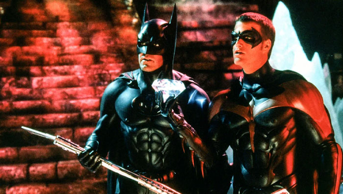 Batman and Robin, iconic duos in superhero costumes, stand side by side holding a diamond in a dramatic setting.