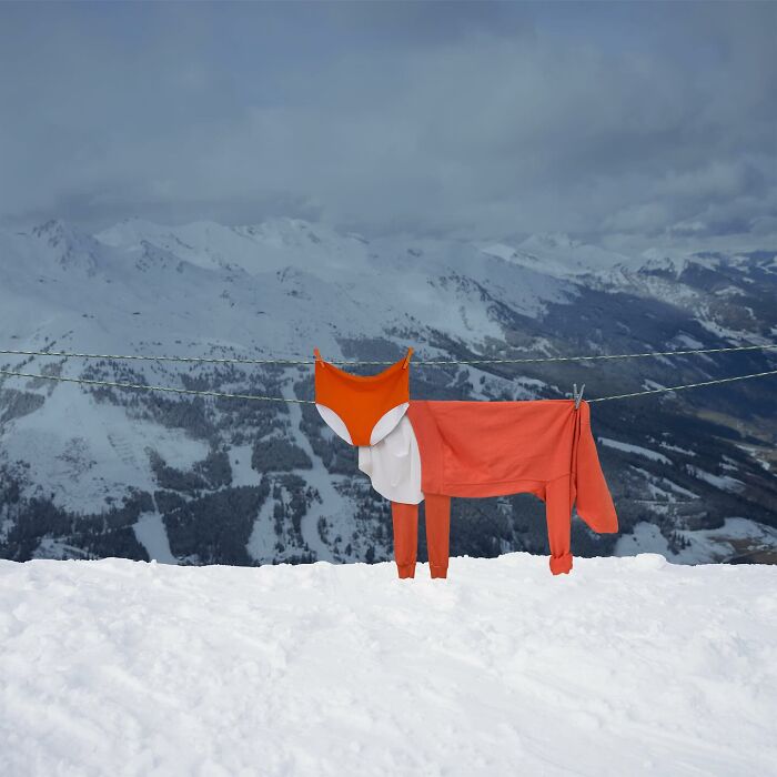 Playful animal made from laundry hanging on a line against a snowy mountainous landscape.