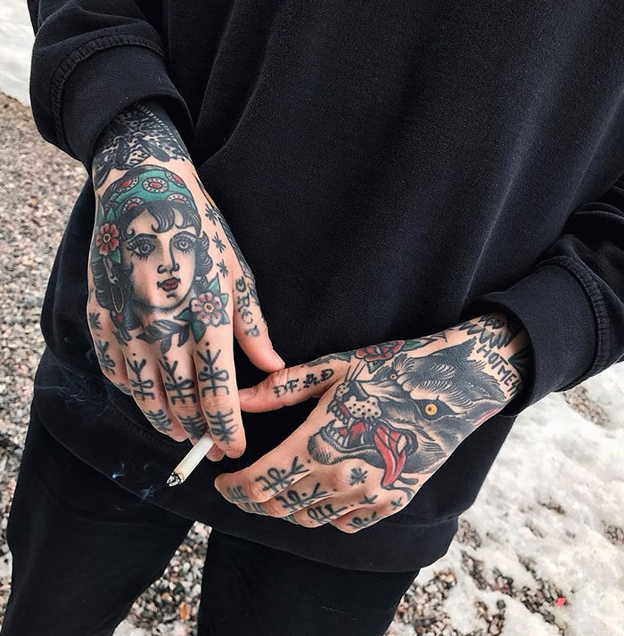  A set of detailed hand tattoos featuring a woman’s face with floral accents and a snarling wolf, combined with symbolic markings on the fingers, providing classic and artistic tattoo ideas for men.