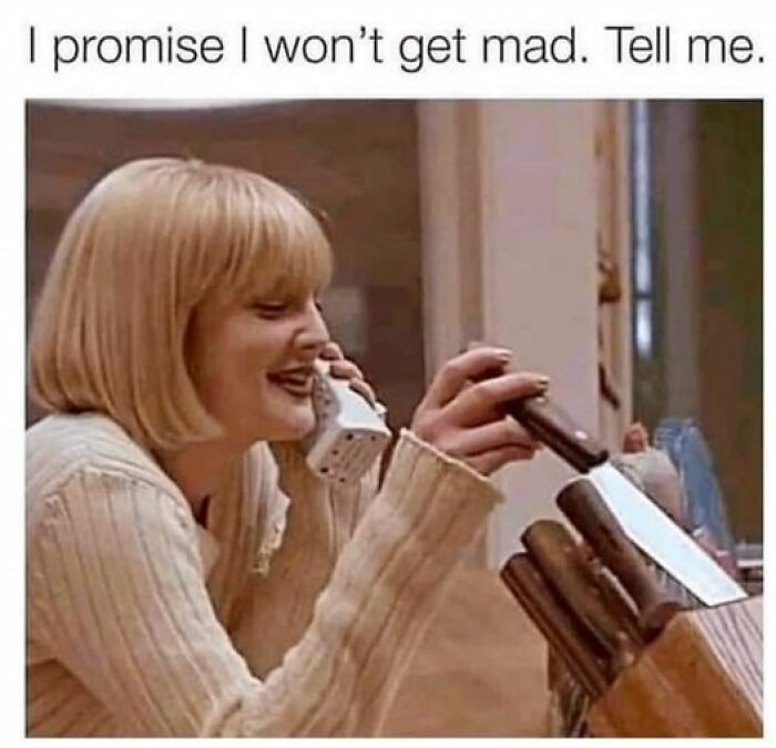 Person smiling on a phone while holding a knife, reflecting twisted and unexpected humor.