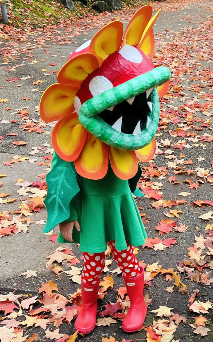 Child in creative Halloween costume standing on a leaf-covered path, showcasing one of the kids' Halloween costume ideas.