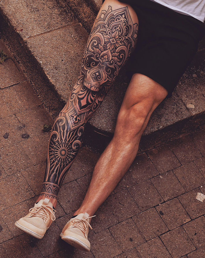  A leg sleeve tattoo showcasing intricate geometric and ornamental patterns that cover the entire leg from the ankle to the thigh, providing bold and detailed tattoo ideas for men.
