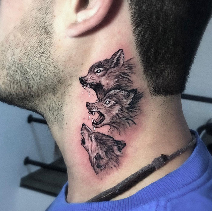 A realistic neck tattoo featuring three howling wolves stacked vertically, each with distinct expressions and details, symbolizing power and connection to nature. Tattoo ideas for men seeking bold and fierce designs.
