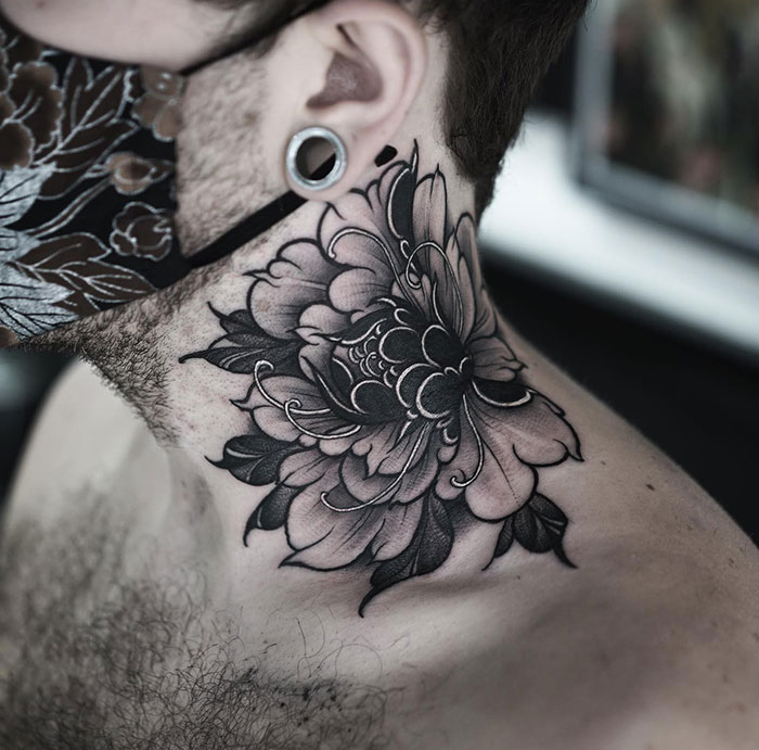  A large black and grey neck tattoo depicting a highly detailed chrysanthemum flower with intricate shading and delicate linework. Tattoo ideas for men seeking bold yet elegant floral designs.