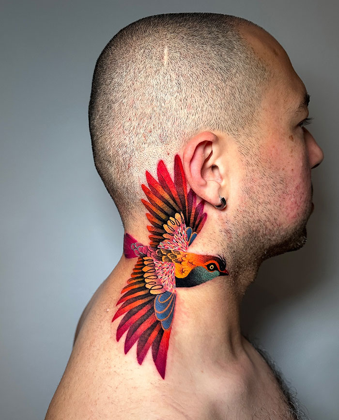  A vibrant tattoo of a colorful bird in flight, wrapping around the side of the neck with detailed shading and bold hues. Tattoo ideas for men who want a dynamic, eye-catching design symbolizing freedom and creativity.