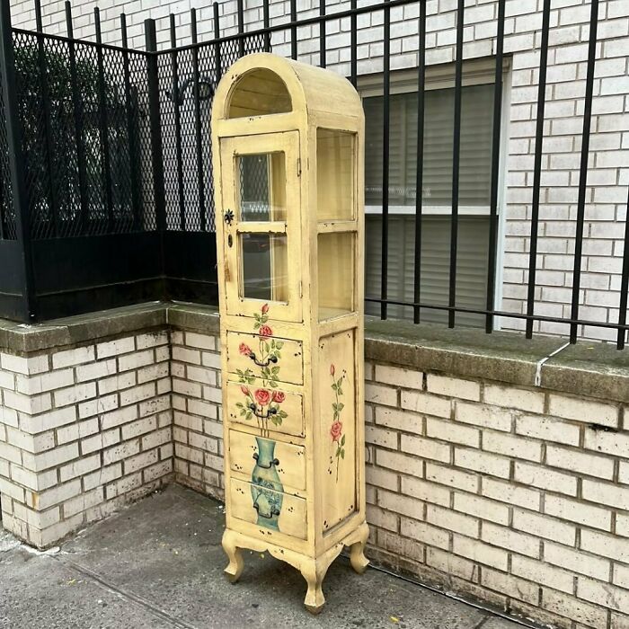 Vintage floral cabinet left on NYC curb for treasure seekers.