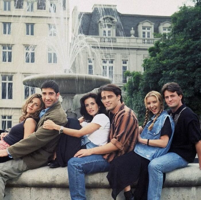 ‘90s group posing happily by a fountain, capturing a wild and wholesome moment.